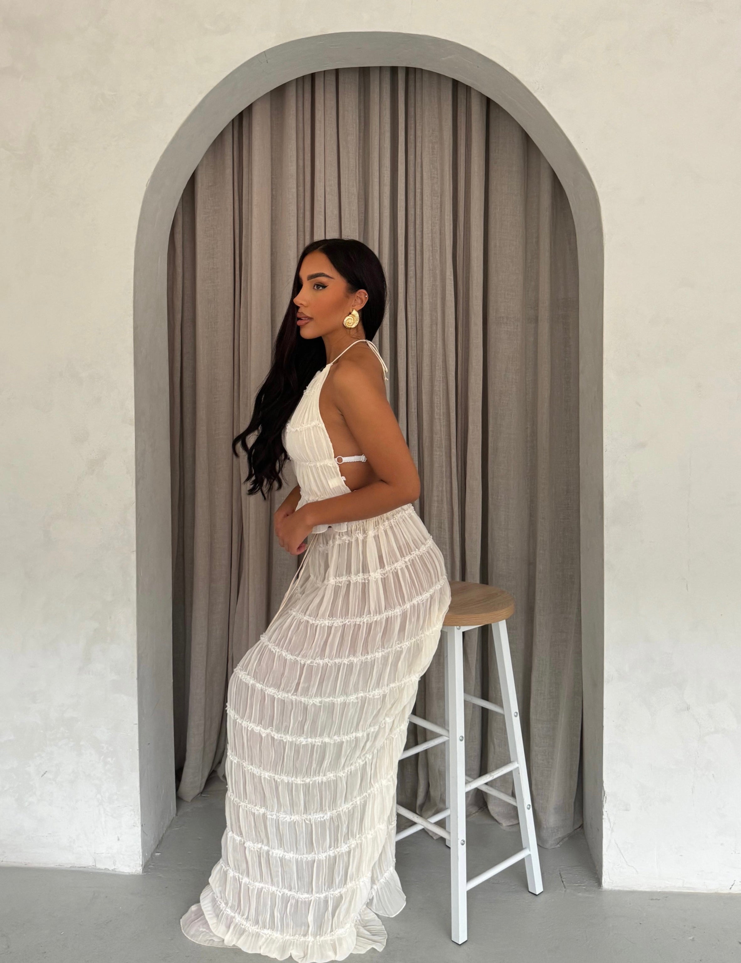 White pleated maxi dress with halter neck, side view