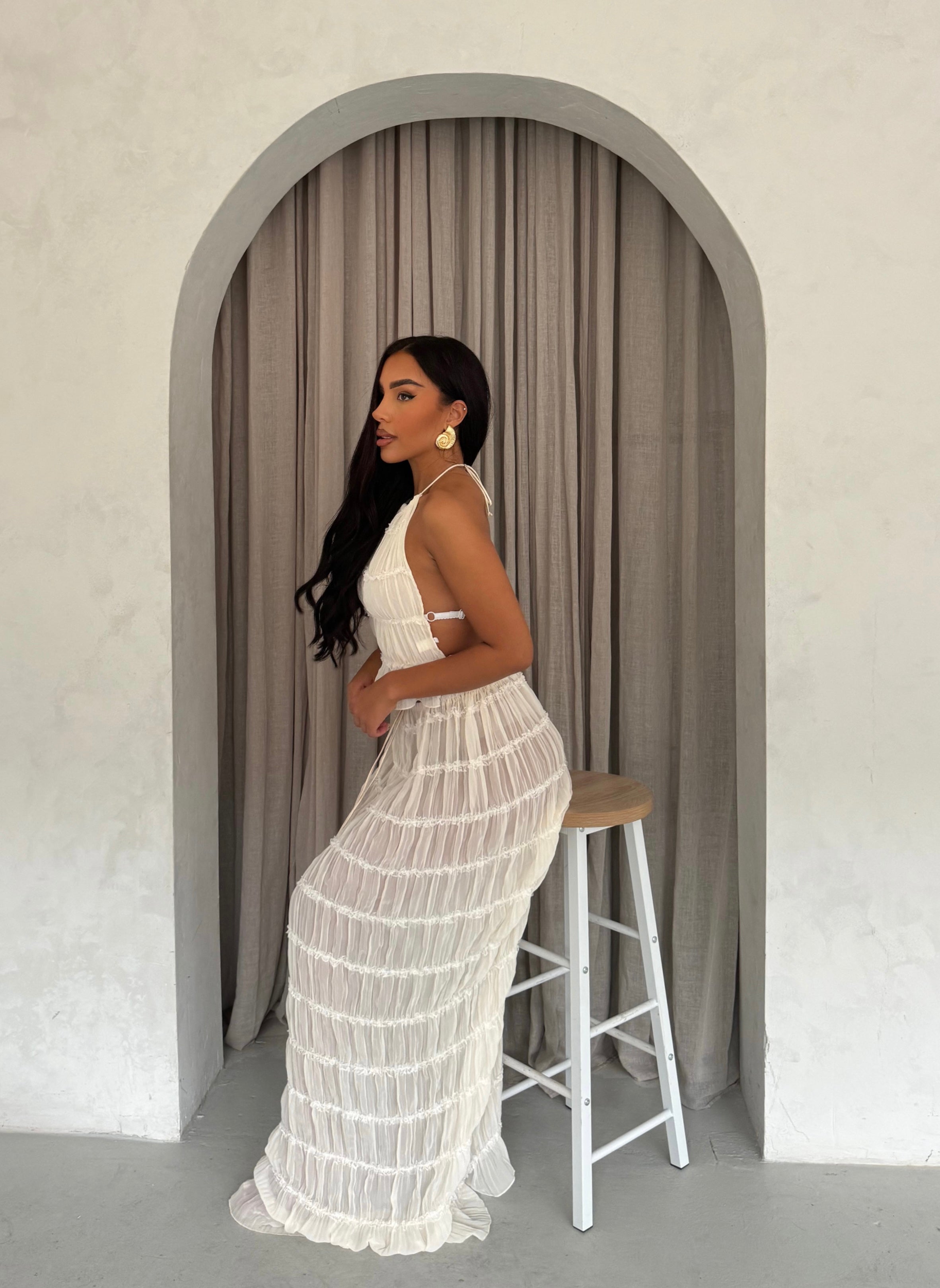 White pleated maxi dress with halter neck, side view