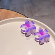 Purple flower-shaped hair clips on a beige plate.