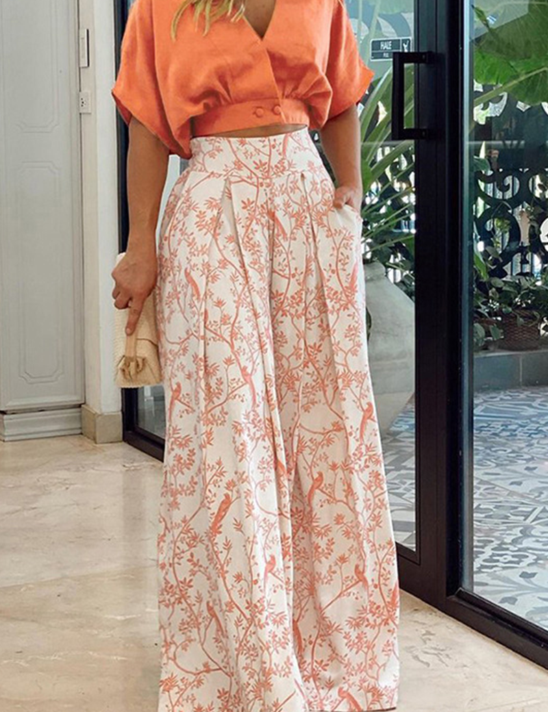 Orange crop top and white pants with bird print, side view