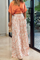Orange crop top and white pants with bird print, side view