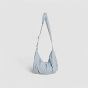 Schoudertas lichtblauw pufferstof met schouderriem detail