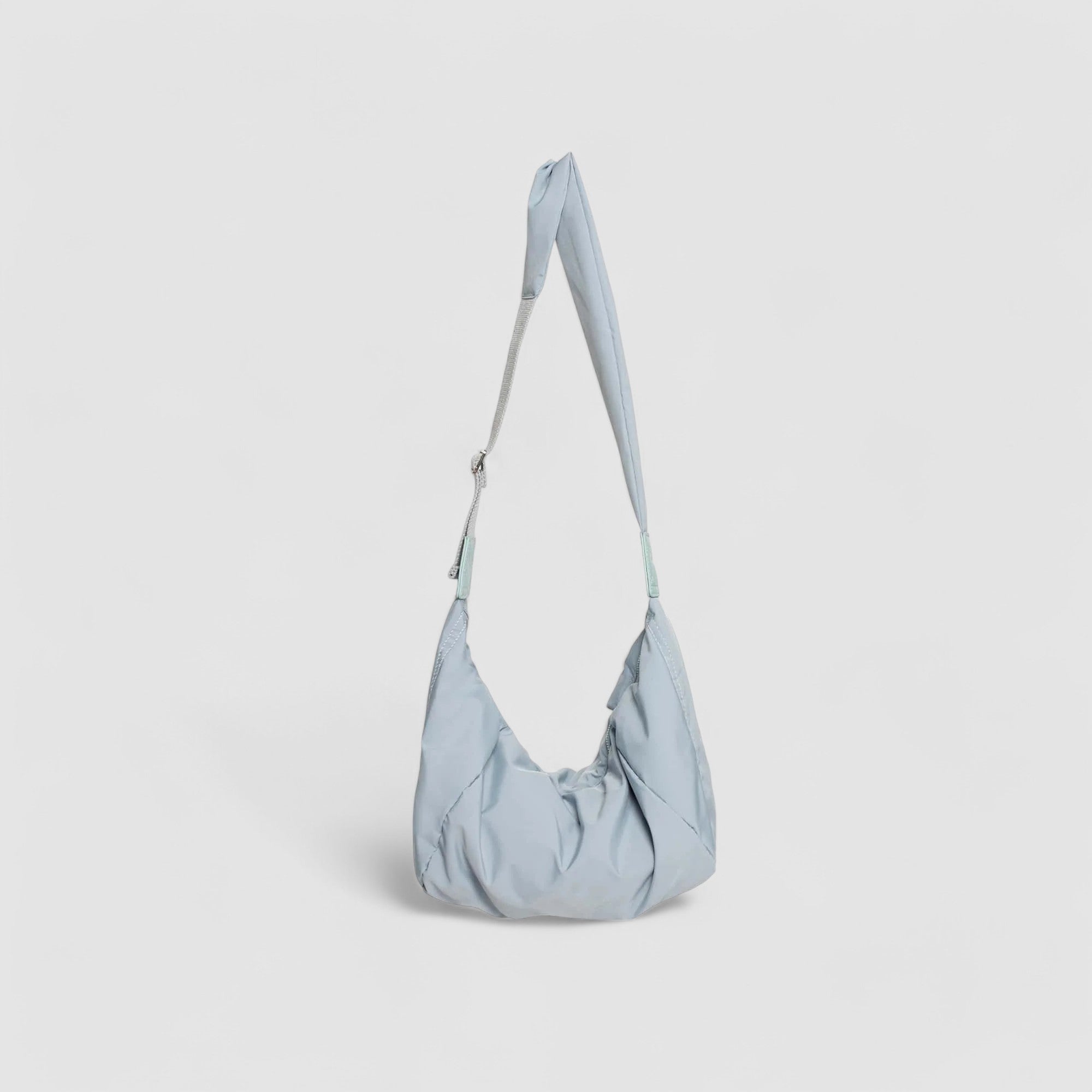 Schoudertas lichtblauw pufferstof met schouderriem detail