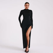 Black maxi dress with high collar and thigh-high slit, front view with hands on hips