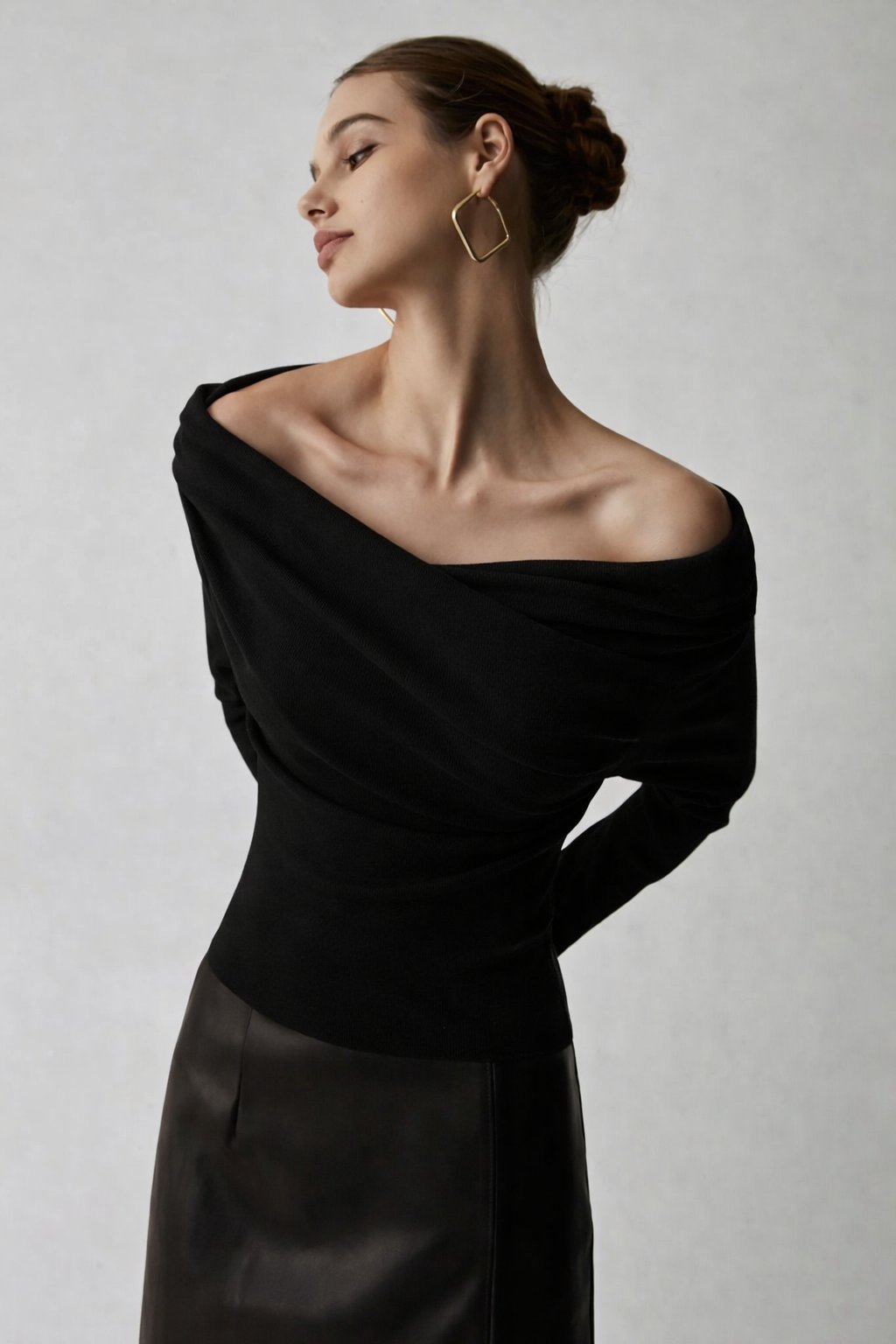 Black off-shoulder sweater with draped neckline, side view
