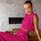 Pink two-piece set with crop top and wide-leg pants seated pose