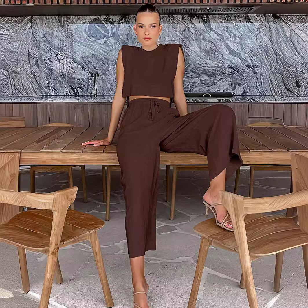 Brown two-piece set with crop top and wide-leg pants seated pose
