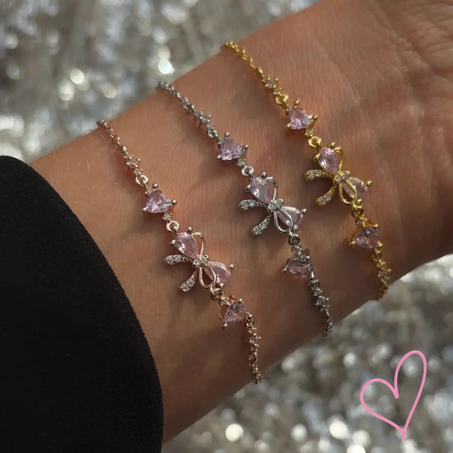 Gold and silver necklaces with pink heart stones, close-up on wrist
