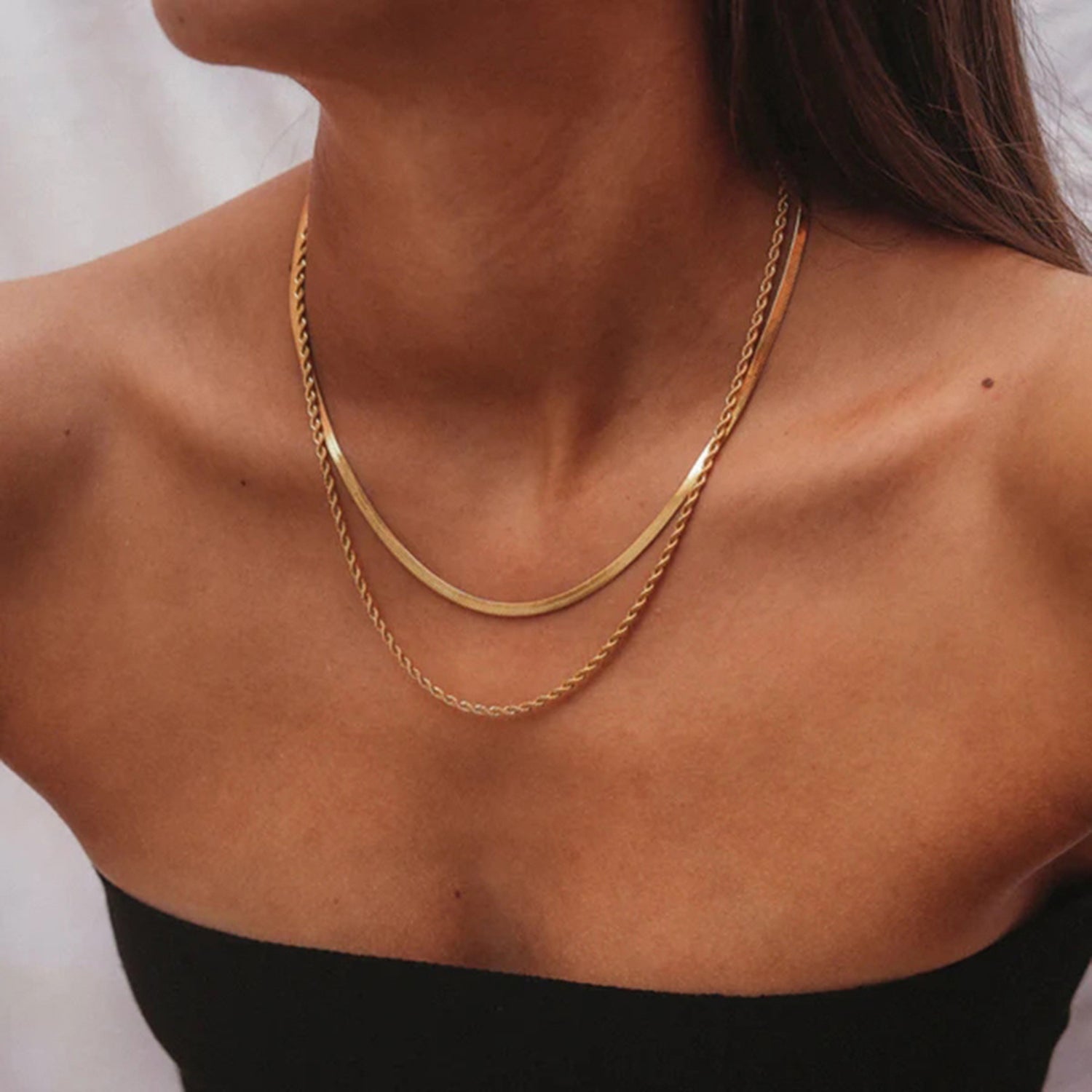 Gold-colored layered necklace on model front view