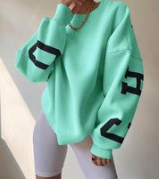 Oversized sweater groen met zwarte letters op mouwen, front view