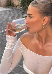 Gold teardrop earrings on model, side profile view