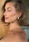 Gold teardrop earrings on model, close-up side view