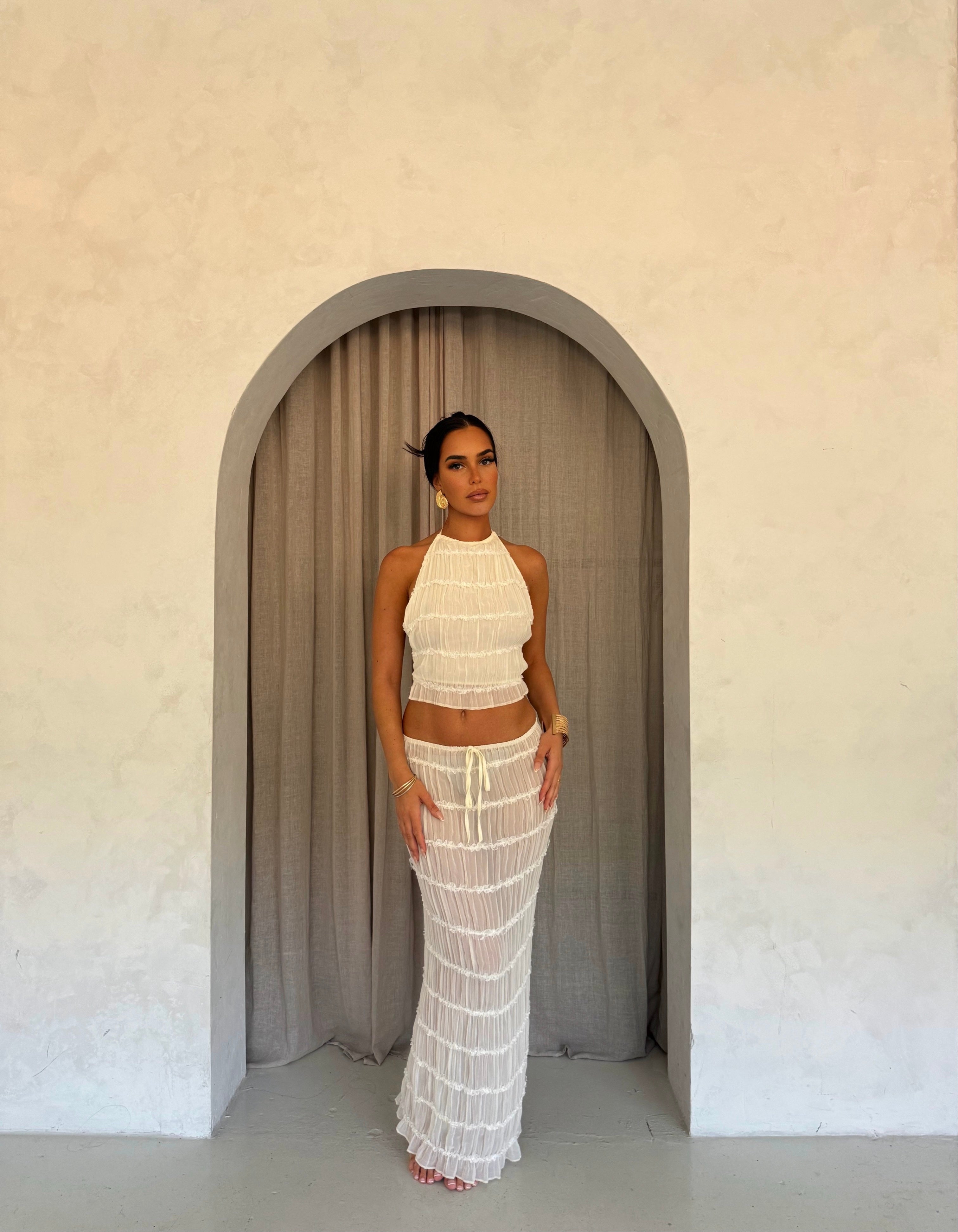 White pleated maxi dress with halter neck, front view