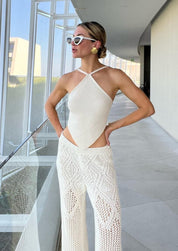 Woman wearing gold shell-shaped earrings with white outfit