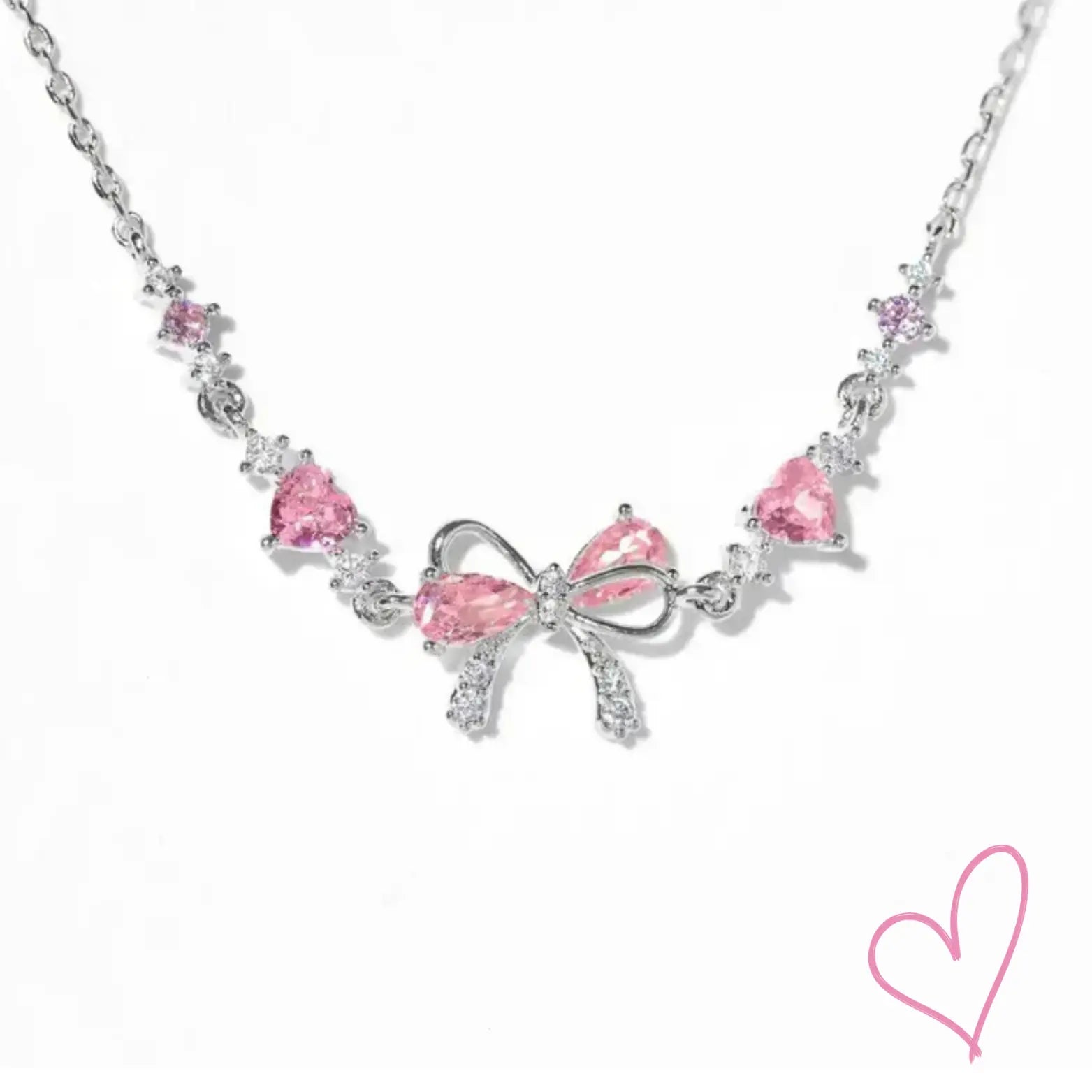 Silver necklace with pink heart stones and bow detail, front view