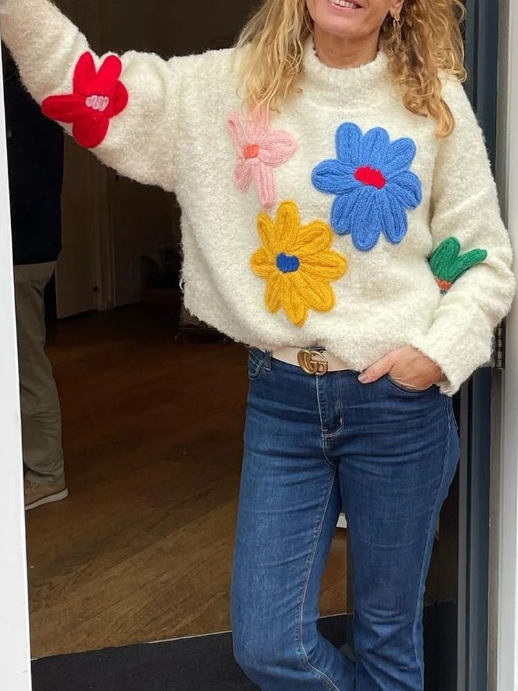 Cream knit sweater with colorful floral appliques three-quarter view
