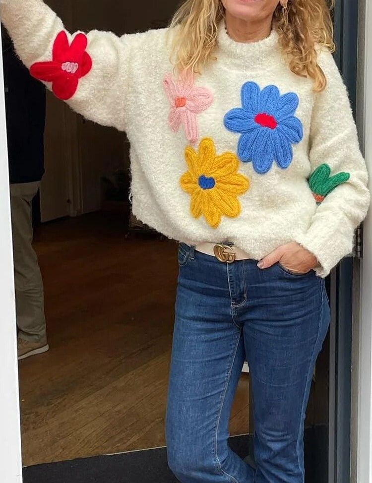 Cream knit sweater with colorful floral appliques three-quarter view