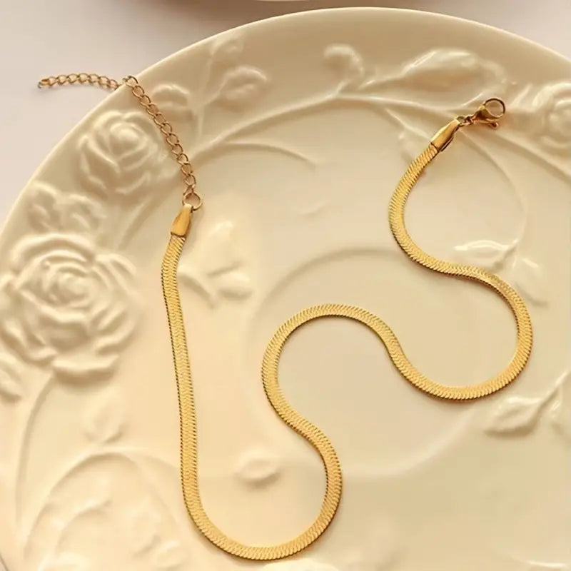 Gold herringbone necklace with clasp on floral plate