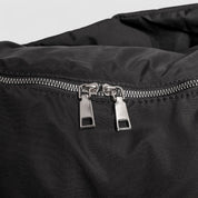 Schoudertas zwart met zilveren ritsdetail close-up