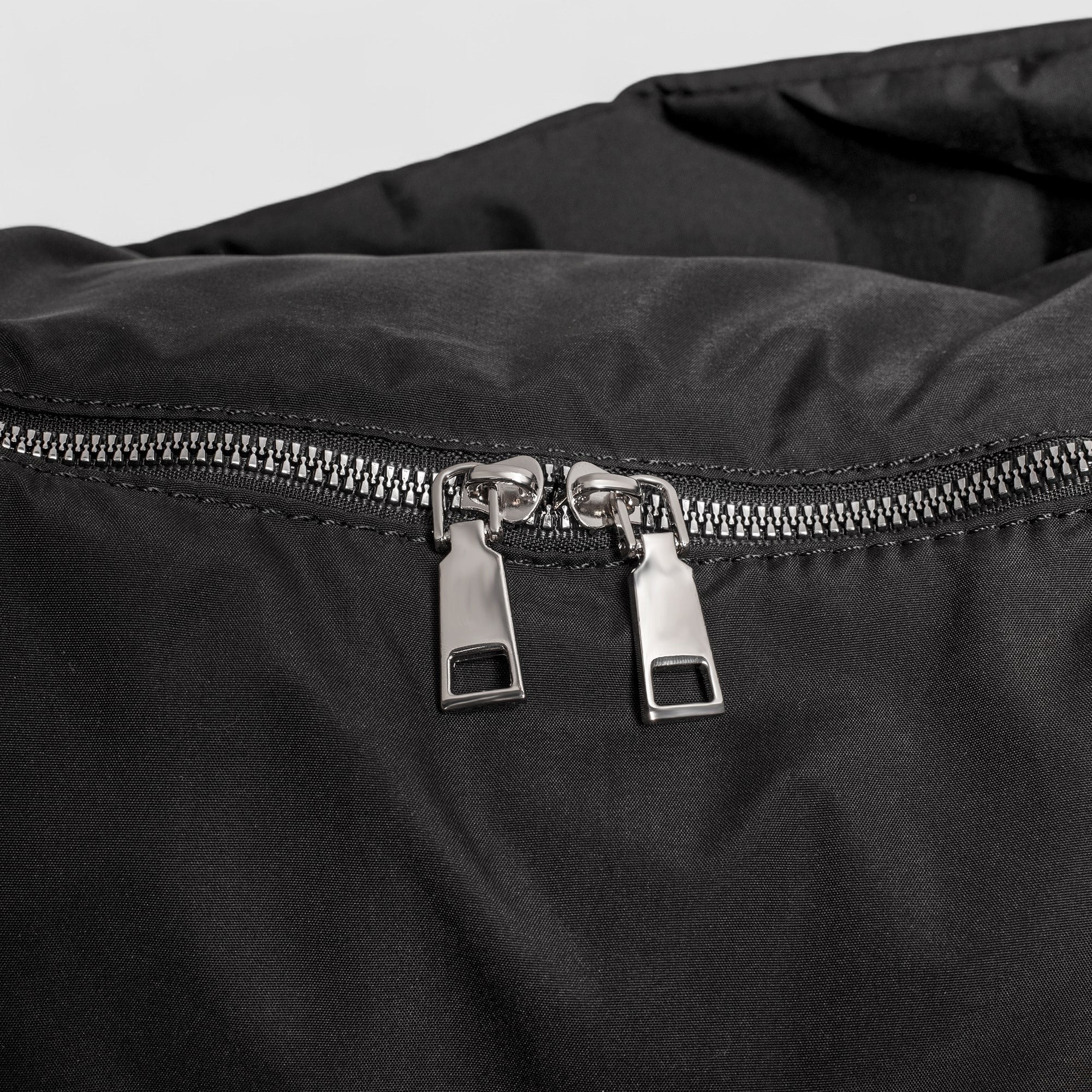 Schoudertas zwart met zilveren ritsdetail close-up