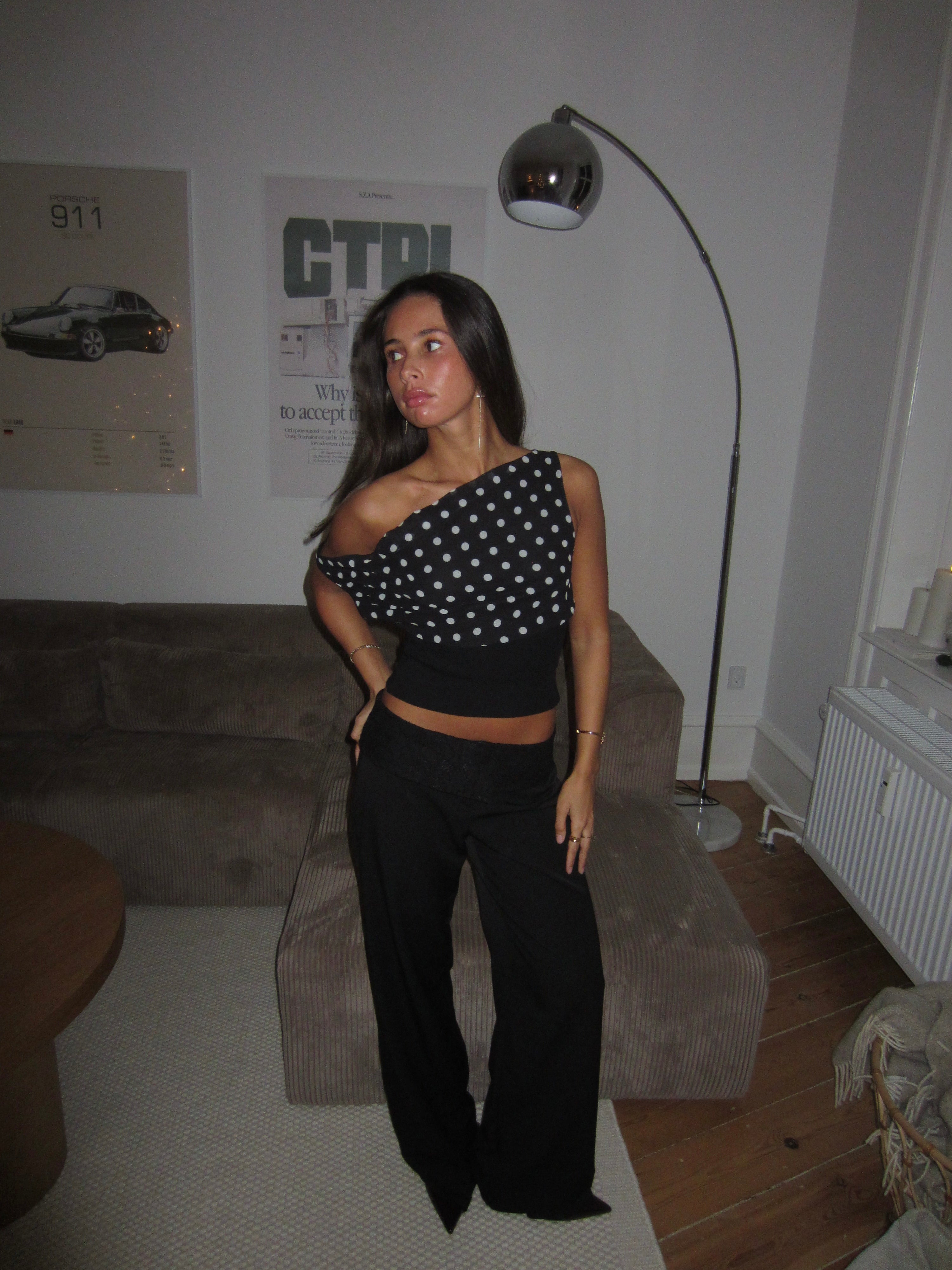 Black top with white polka dots and asymmetrical sleeve front view