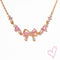 Rose gold necklace with pink heart stones and bow detail, front view