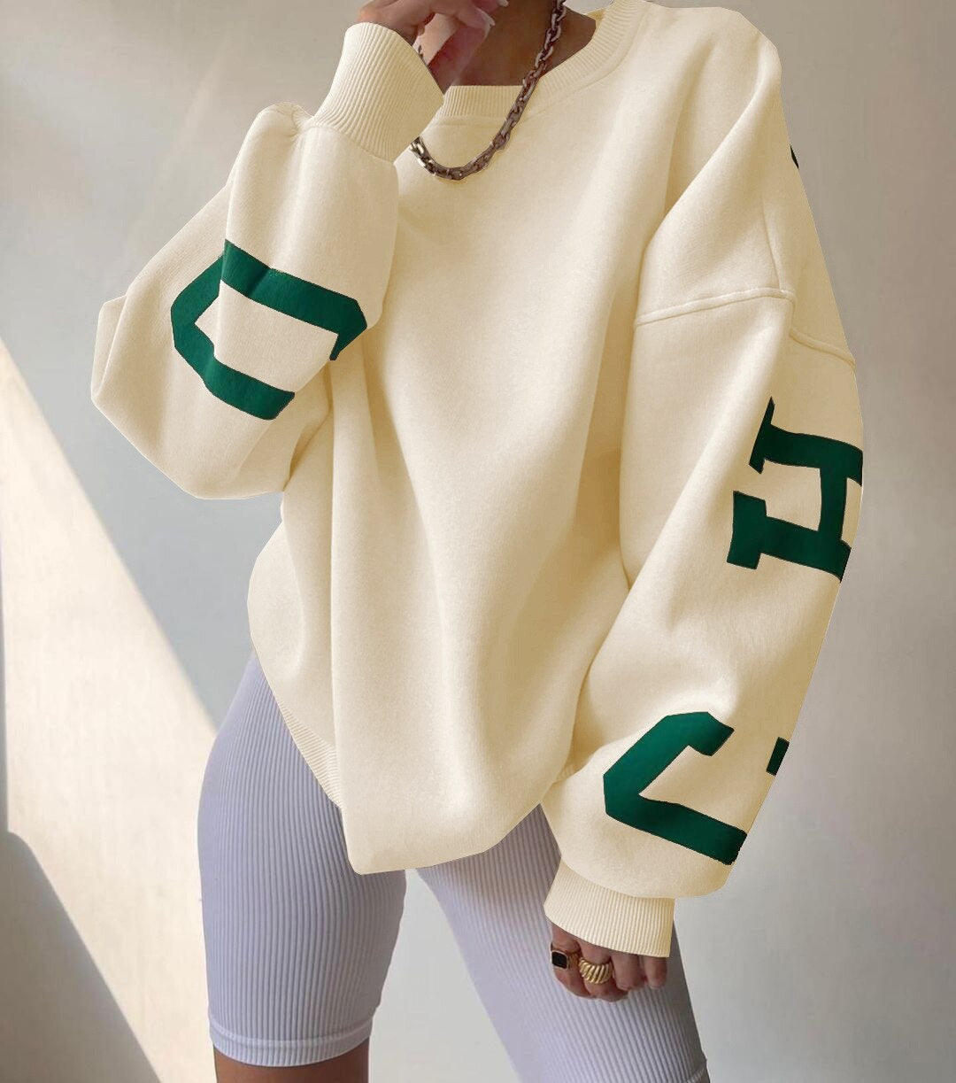 Oversized sweater beige met groene letters voorzijde