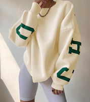 Oversized sweater beige met groene letters voorzijde