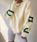 Oversized sweater beige met groene letters voorzijde