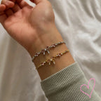 Gold and silver necklaces with pink heart stones, worn on wrist