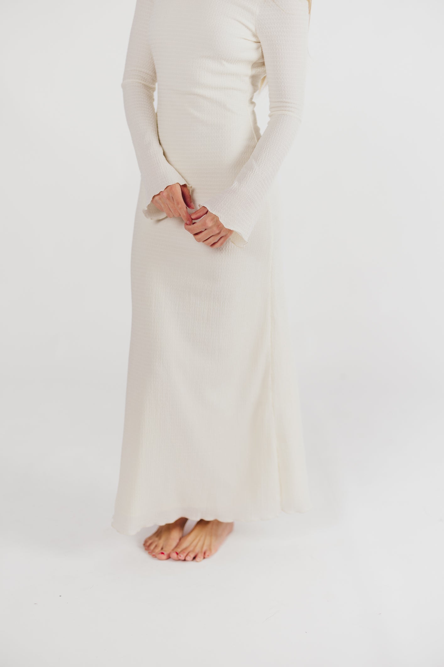 Cream textured maxi dress with bell sleeves close-up detail