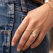 Gold chain bracelet with adjustable design worn on hand with denim background
