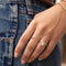 Gold chain bracelet with adjustable design worn on hand with denim background