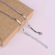 Silver herringbone necklace with clasp detail on wooden block