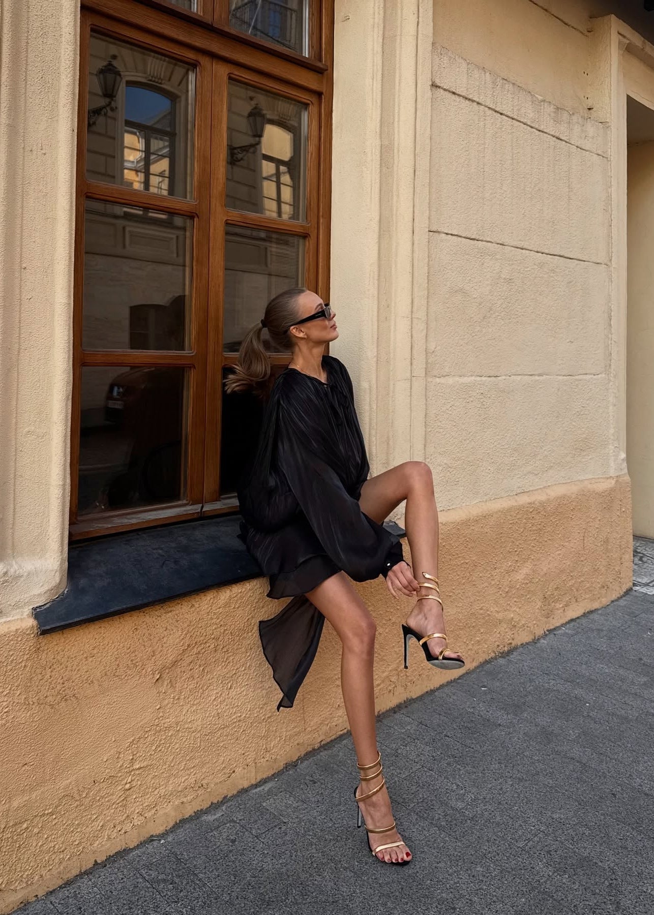 Black satin blouse with keyhole neck and peplum hem sitting side view
