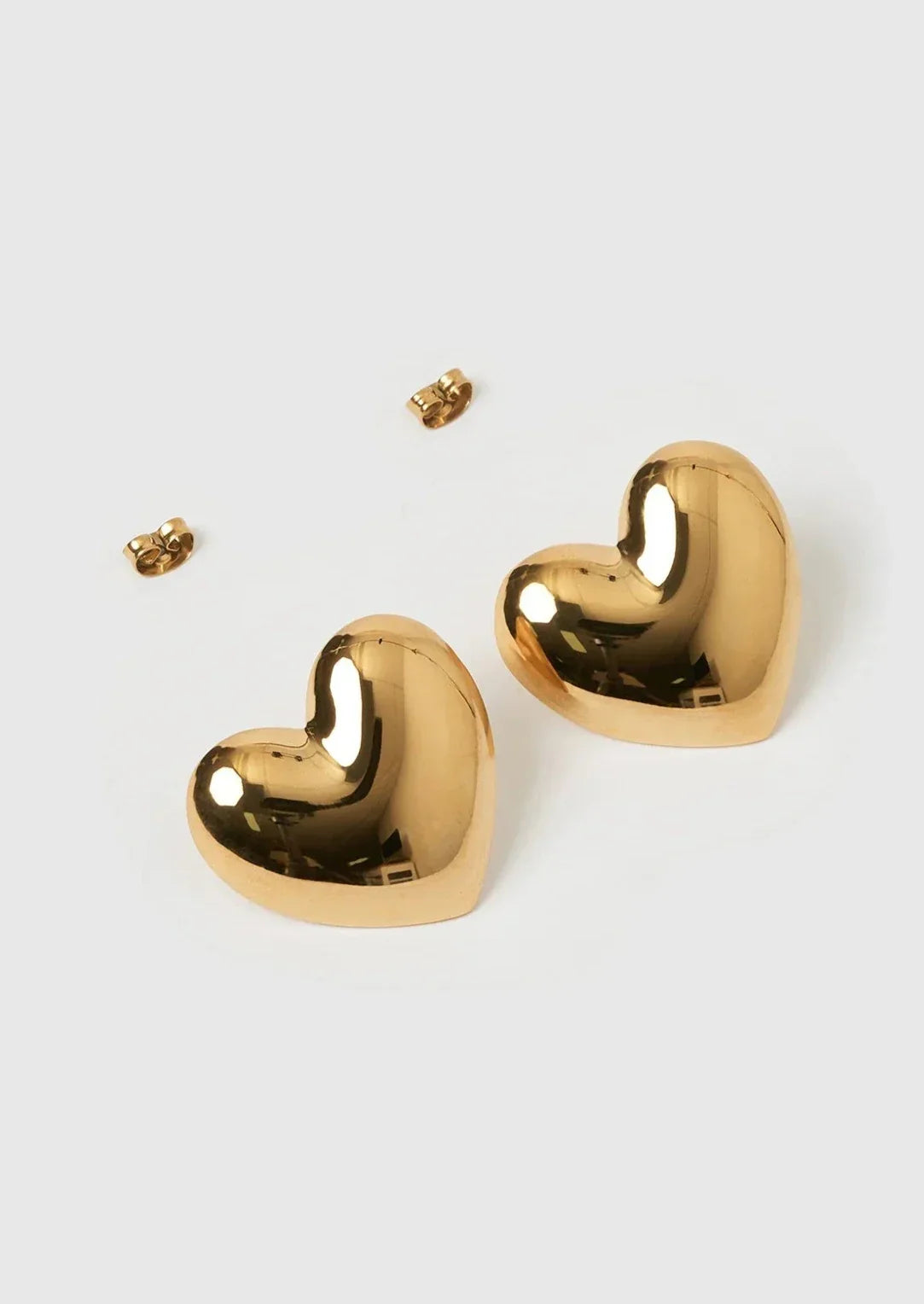 Gold heart-shaped stud earrings with posts and backs detail shot