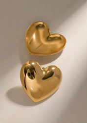 Gold heart-shaped stud earrings angled view