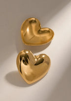 Gold heart-shaped stud earrings angled view