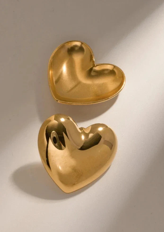 Gold heart-shaped stud earrings angled view
