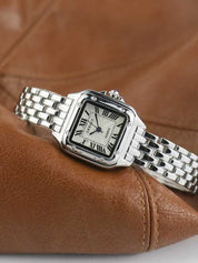 Silver wristwatch with Roman numerals and guilloche dial on brown leather background