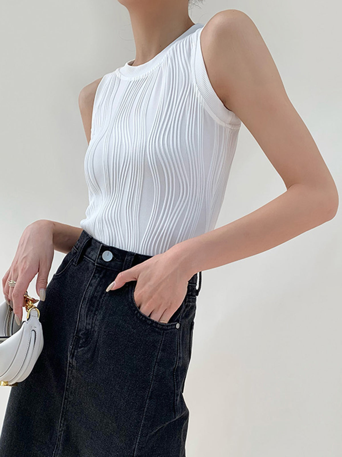 White ribbed sleeveless top with denim jeans front view, hand in pocket