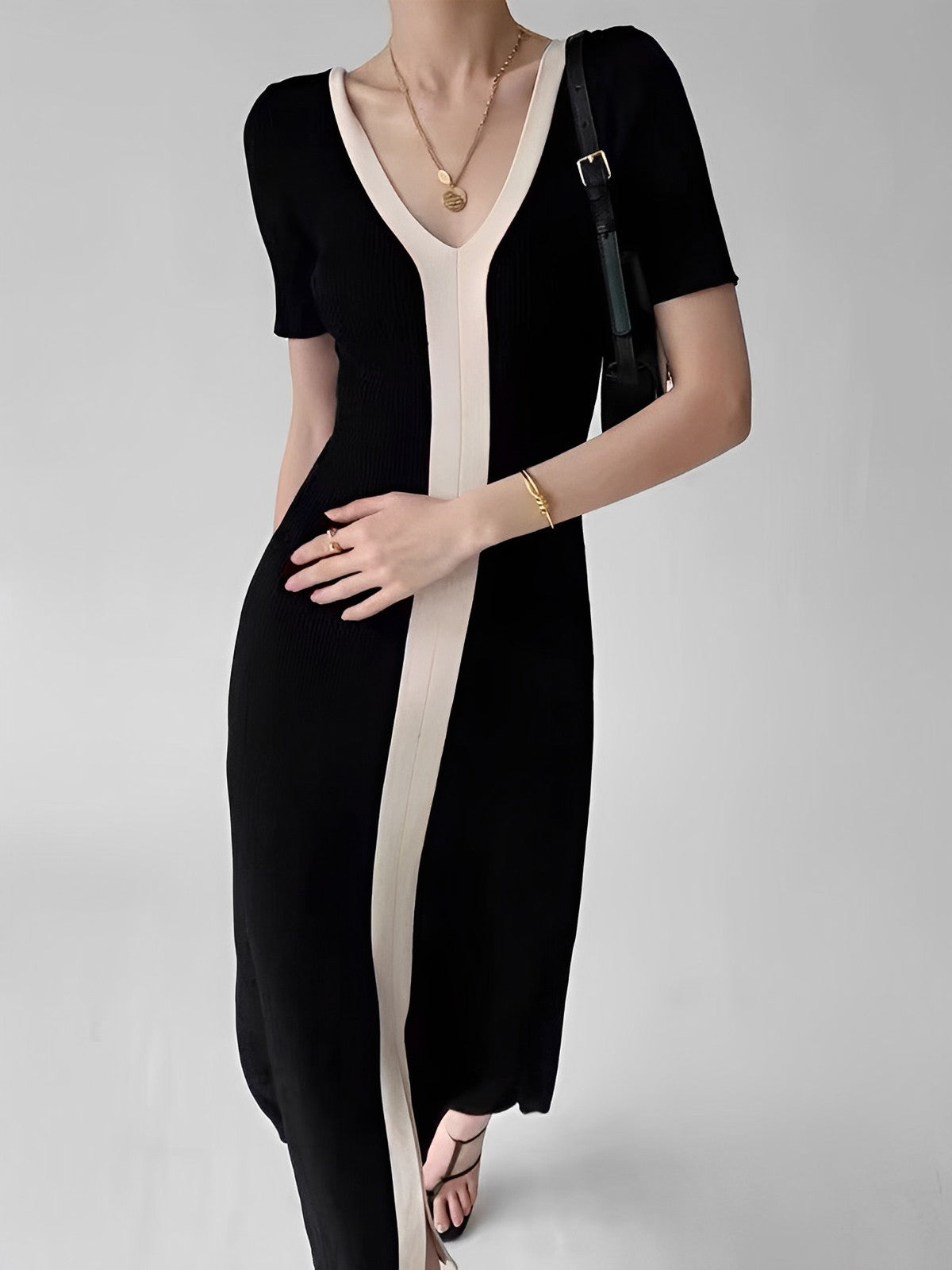 Black and white striped dress with V-neck front view with hand on hip