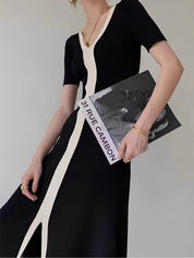 Black and white striped dress with V-neck side view holding magazine