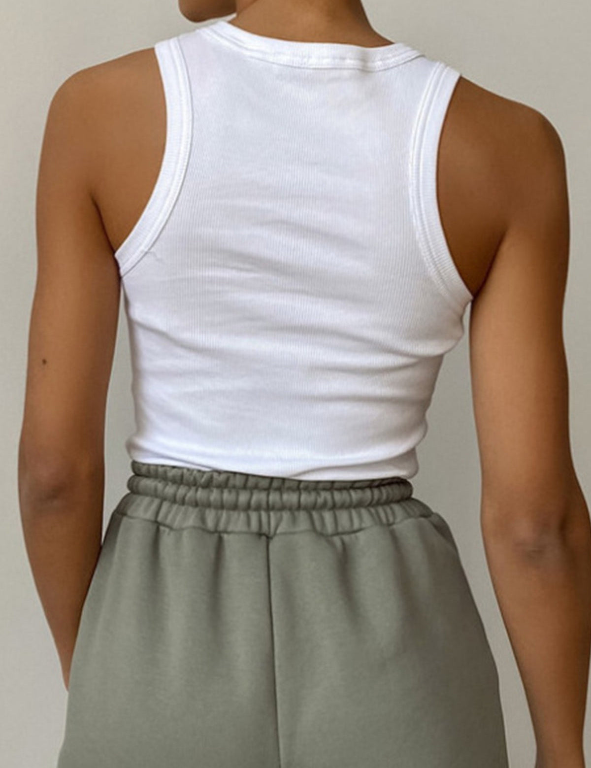 White ribbed tank top back view with gray pants