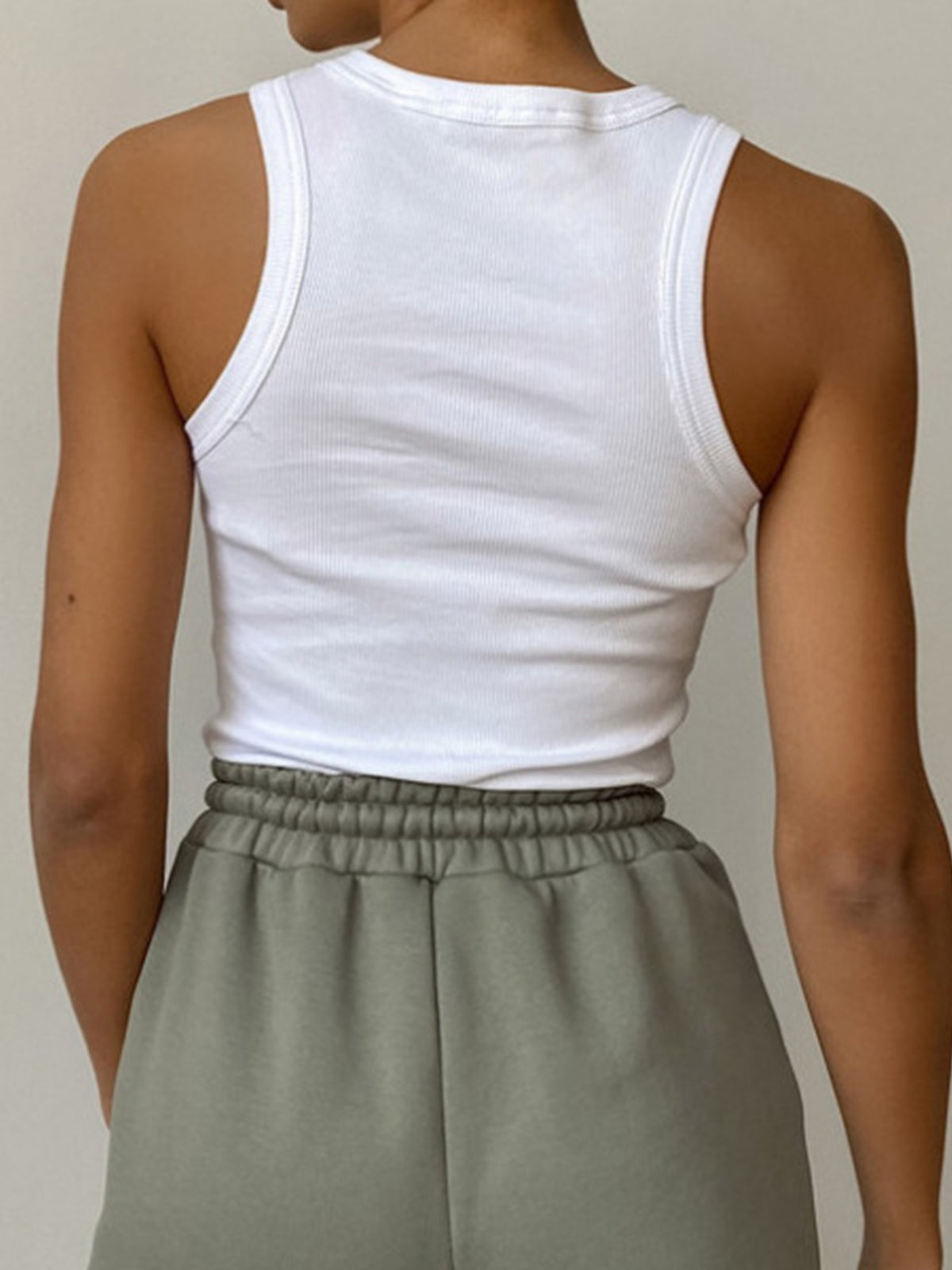 White ribbed tank top back view with gray pants