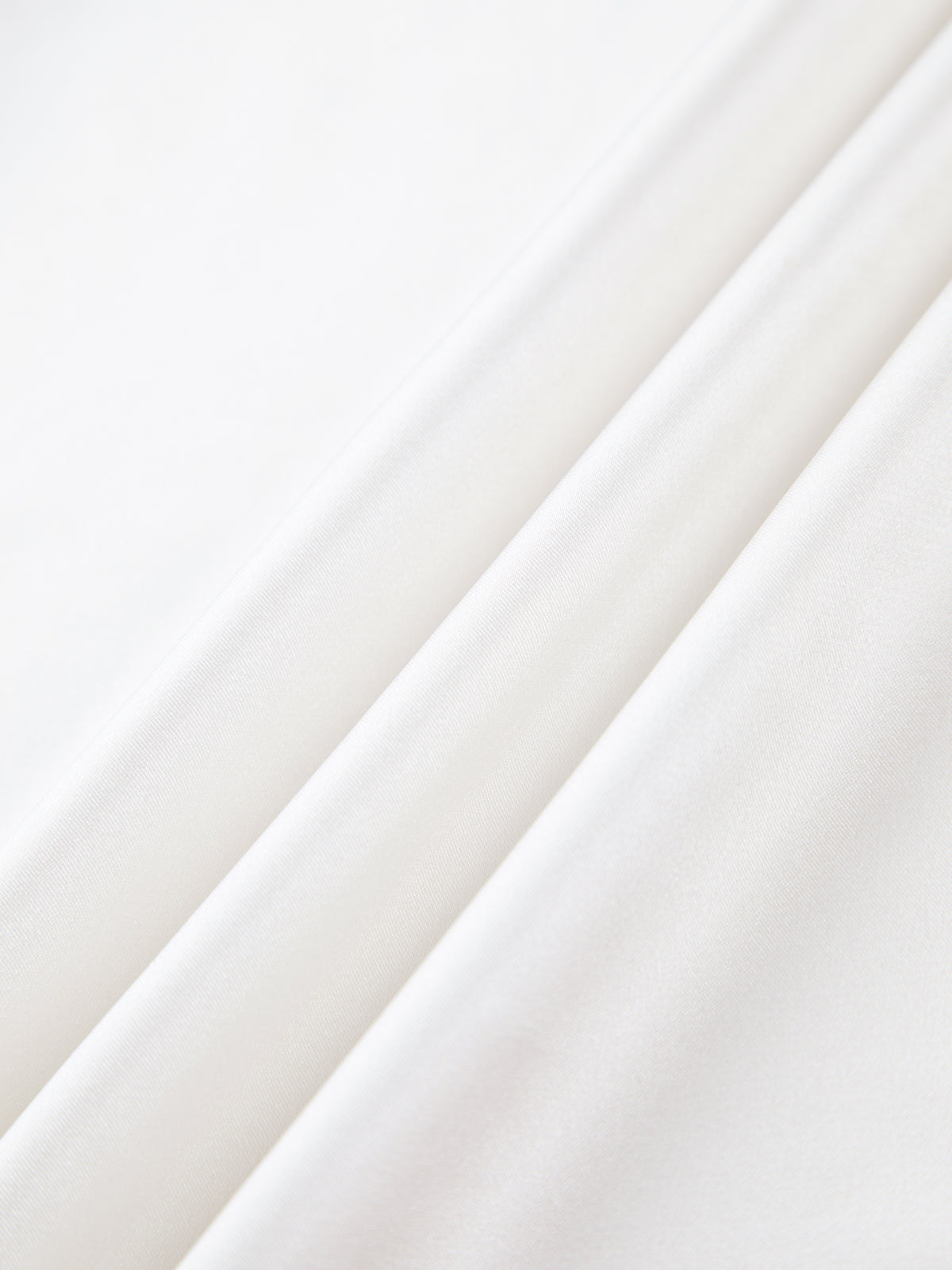 Close-up of white satin fabric with smooth texture