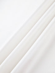 Close-up of white satin fabric with smooth texture