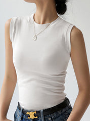 White sleeveless mock-neck top worn with jeans and belt side view