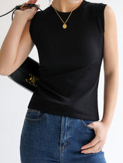 Black sleeveless mock-neck top worn with jeans and black bag front view