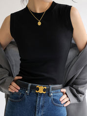 Black sleeveless mock-neck top worn with gray blazer and jeans front view